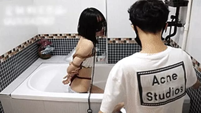 GG47 - A fair-skinned girl wearing sexy lingerie is bound with ropes in a bathtub and subjected to water jets.