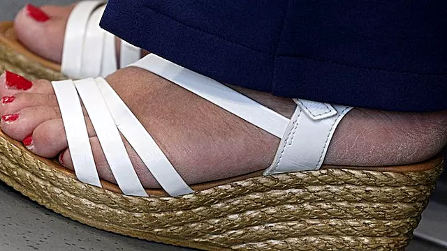 Hot foot fetish admiration. Cute toes and red polish nails, suckable sexy heel with sandals, skin feet over view